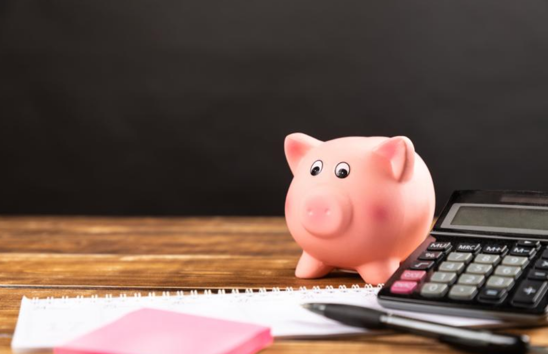 핑크색 돼지 저금통과 계산기가 놓여있다.