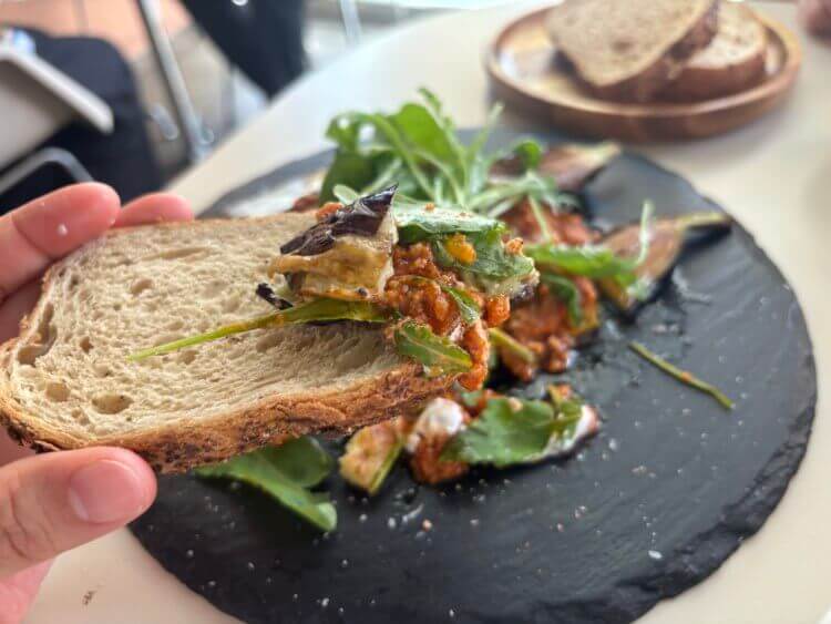 호밀빵 위에 라구소스&amp;#44; 구운 가지&amp;#44; 루꼴라&amp;#44; 샤워크림을 올려 놓은 사진