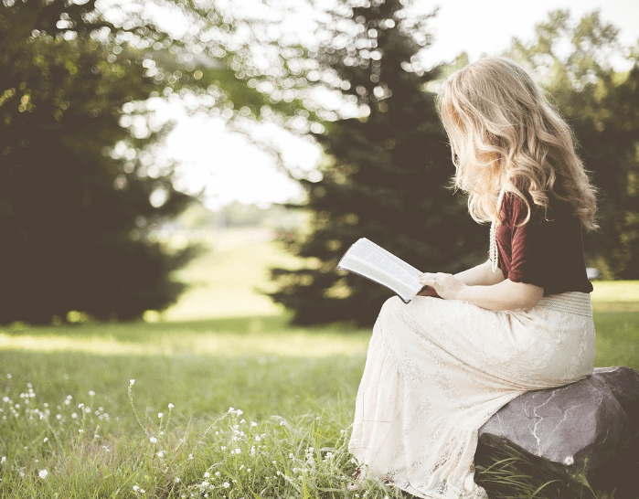 야외에서 책을 읽고 있다.