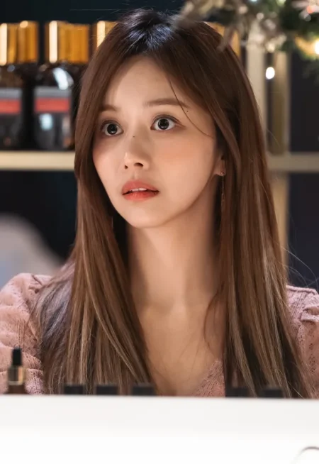 어느 실내를 배경으로 긴 갈색 머리에 분홍색 상의를 입고 있는 드라마 7인의 탈출의 노팽희 캐릭터