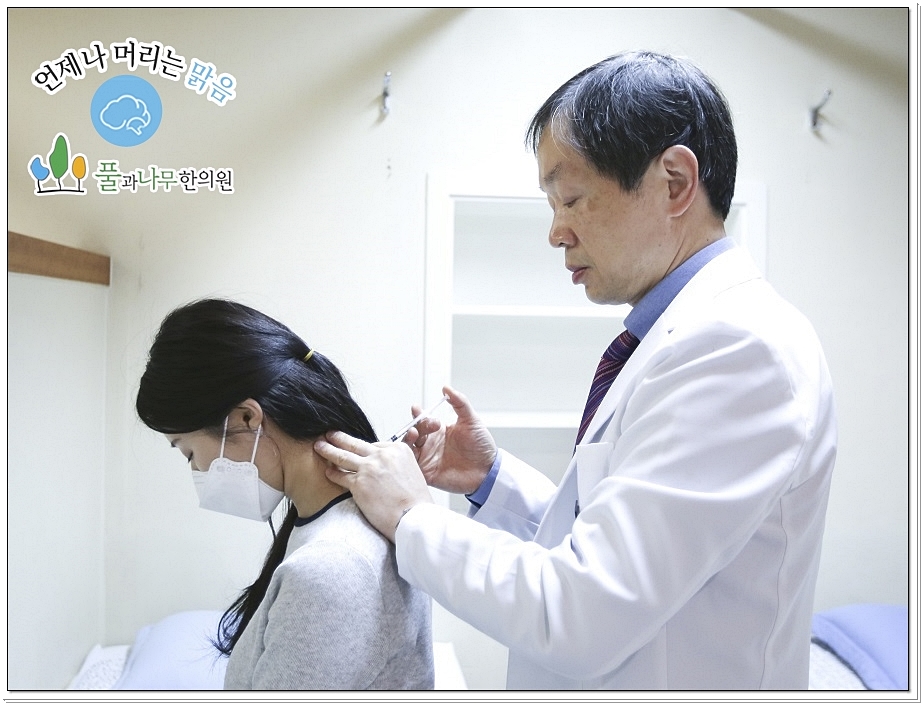 환자의 목 뒤에 약침을 놓고 있는 한의사의 옆모습