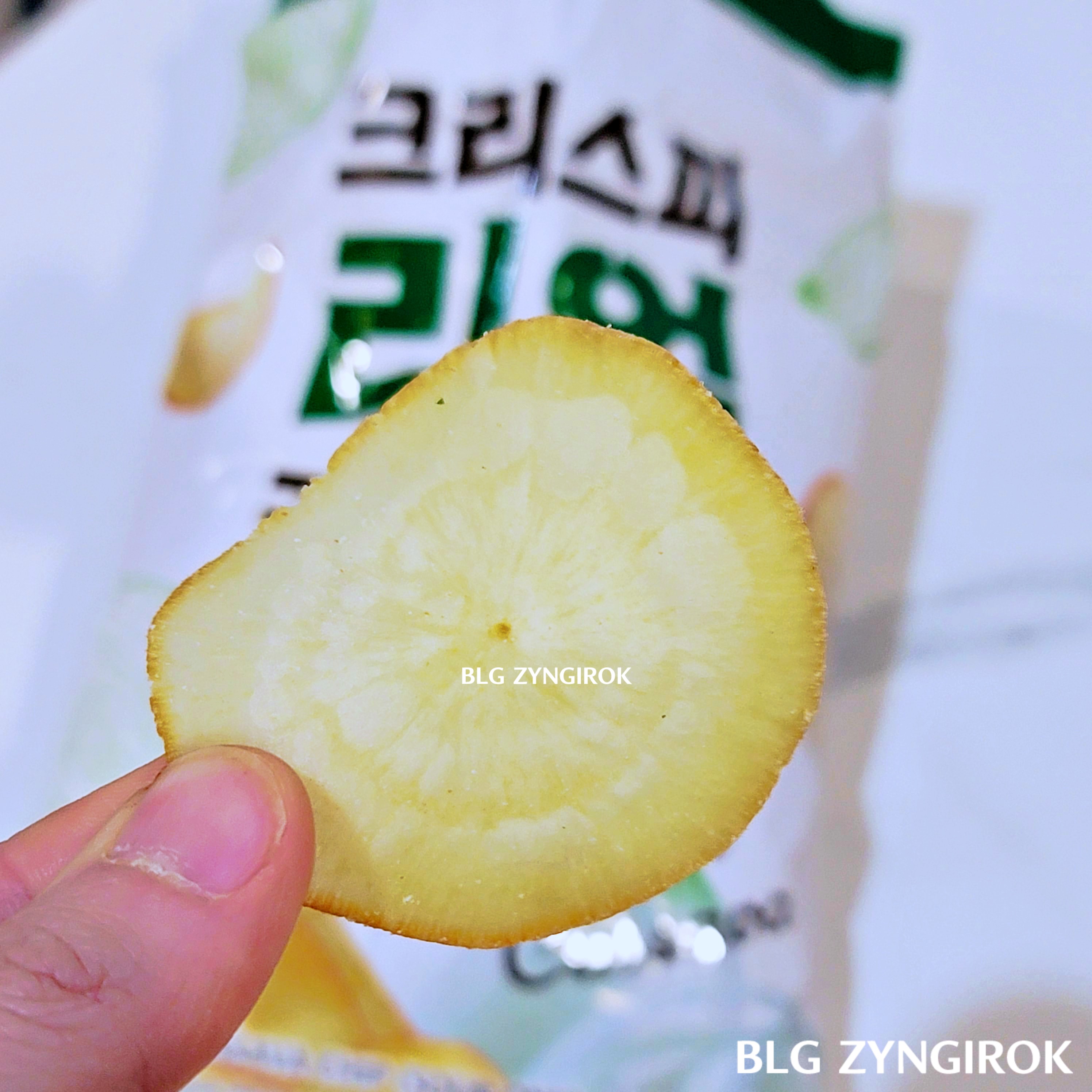 이마트 판매중인 크리스피 리얼 카사바칩 - 사워어니언맛 칩 한 개를 들고 있다.