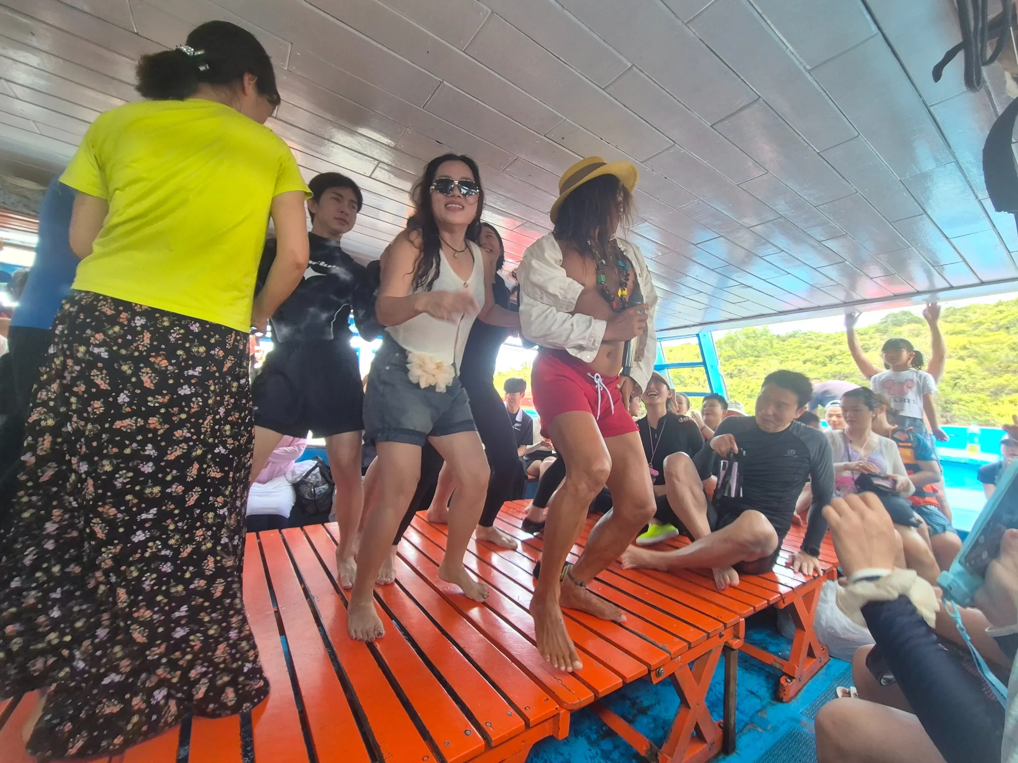 배 위에서 진행되는 댄스 파티 장면. 관광객들이 무대 위에서 신나게 춤을 추며 즐기는 모습