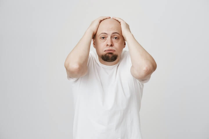 탈모로-머리를-감싸쥐고-있는-남성
