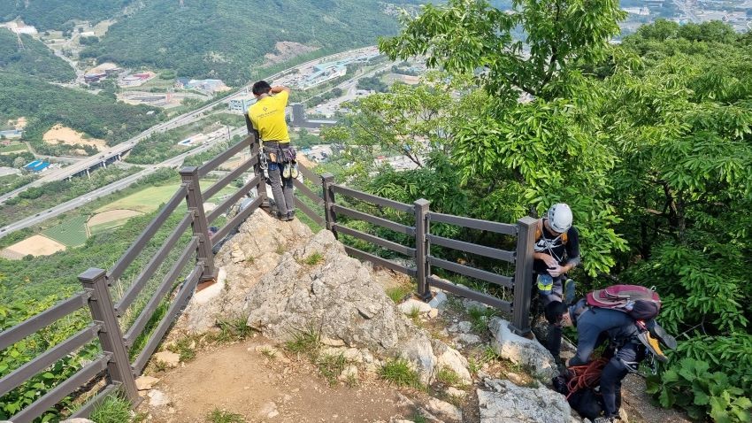 정상 안전 난간 코너에 노란샤스 남 1, 우측에 남 2, 가운데 남자는 흰헬맷,