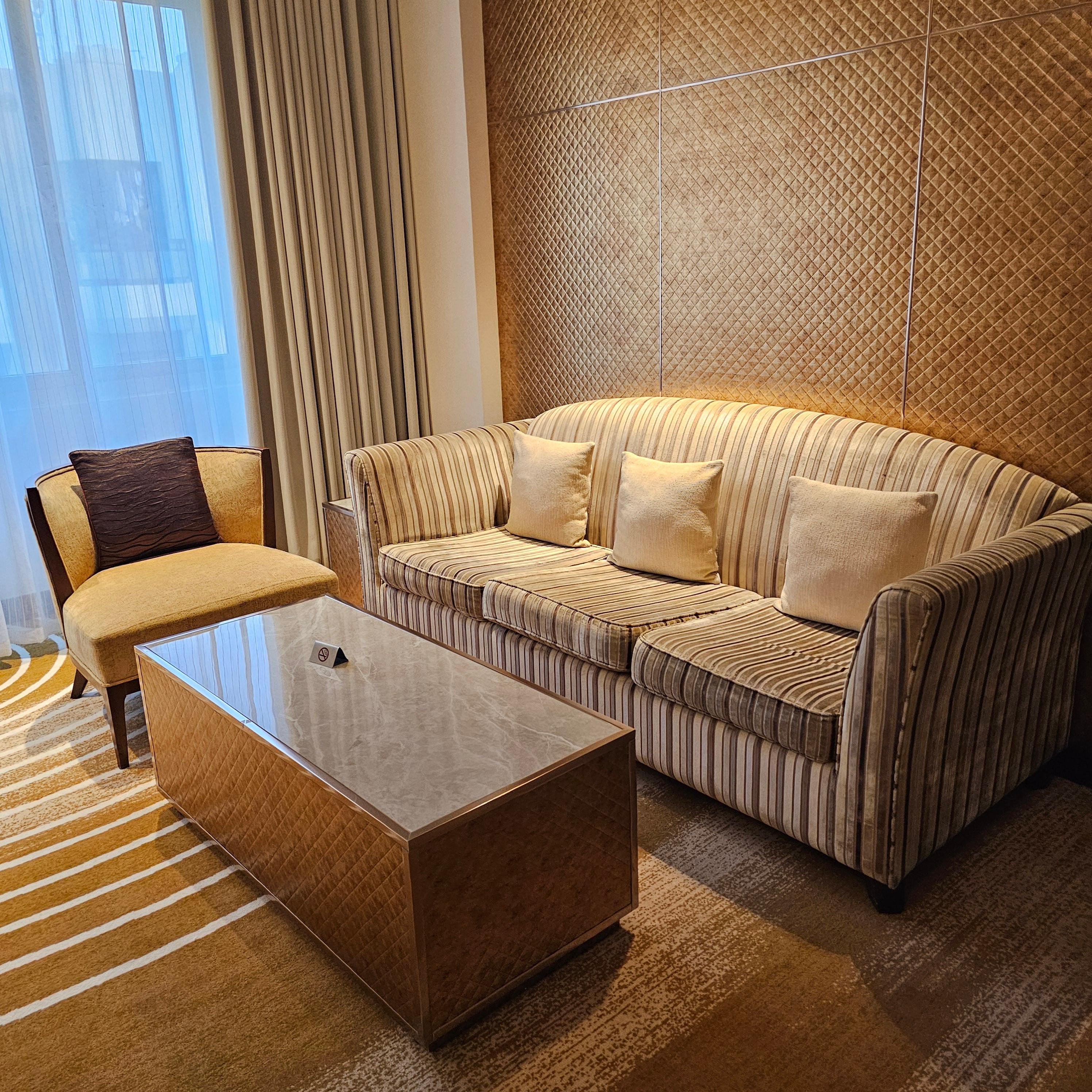 두바이 아시아나 호텔 객실 내부 침대와 소파 그리고 책상