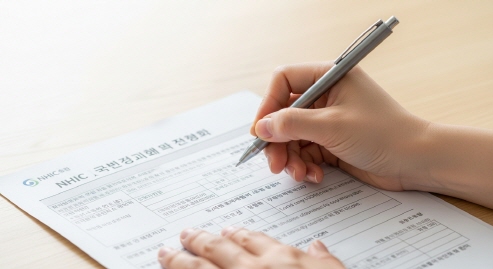 신청서를 작성하는 보호자의 손