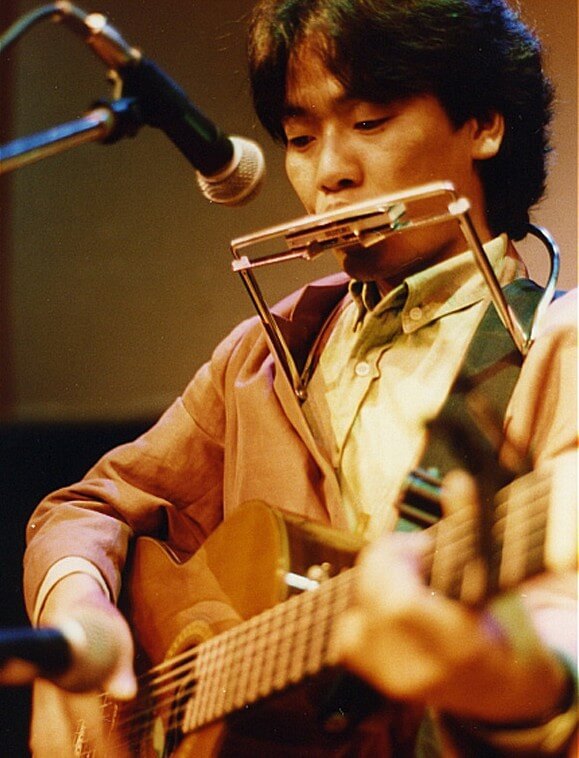 김광석이-기타를-치고-하모니카를-부르는-컬러-사진