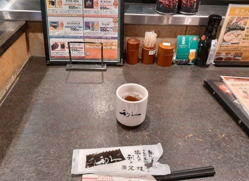 카운터 위에 컵과 젓가락이 올려져 있다.