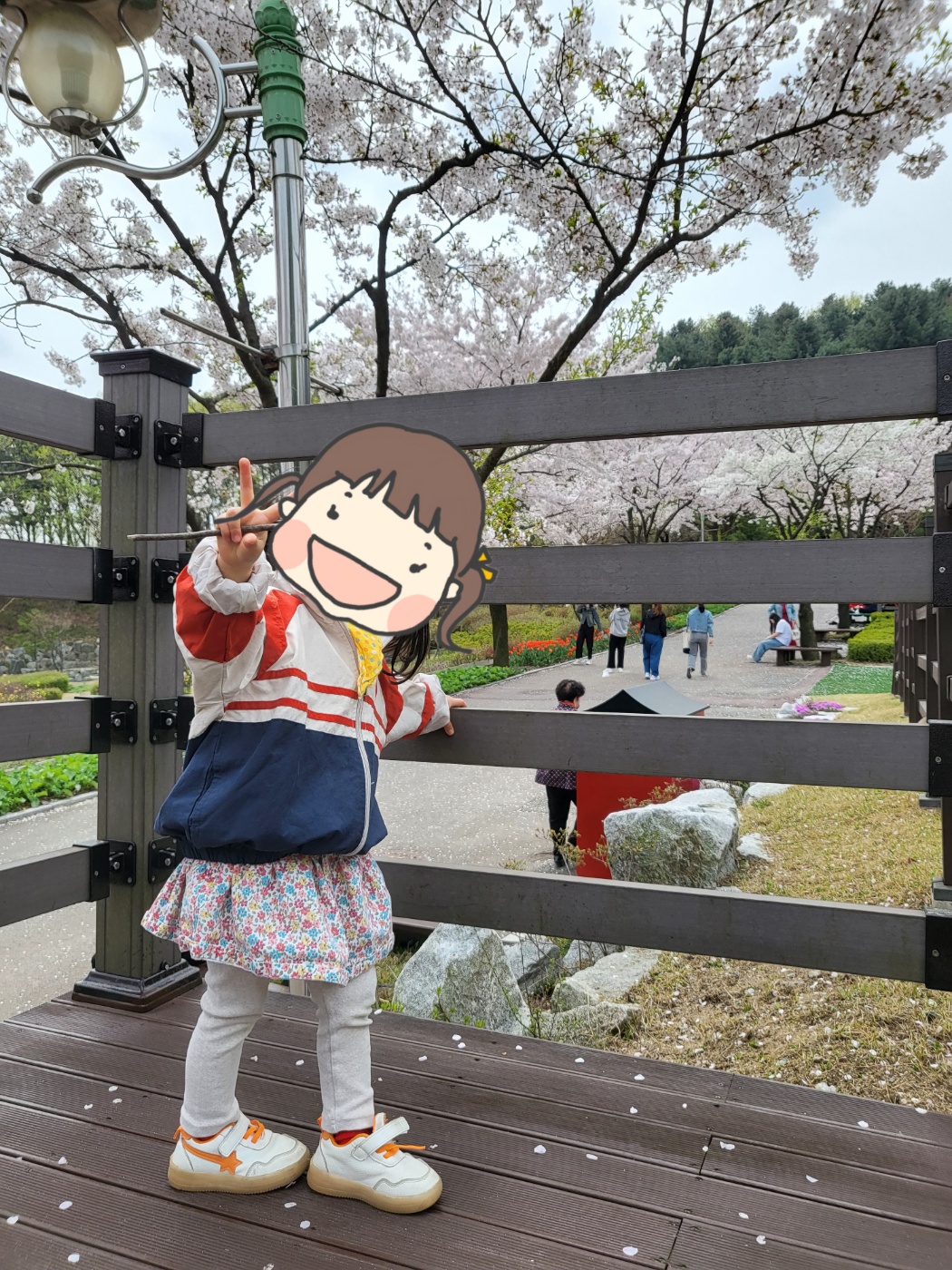 벚꽃 앞에서 포즈를 취하는 아이