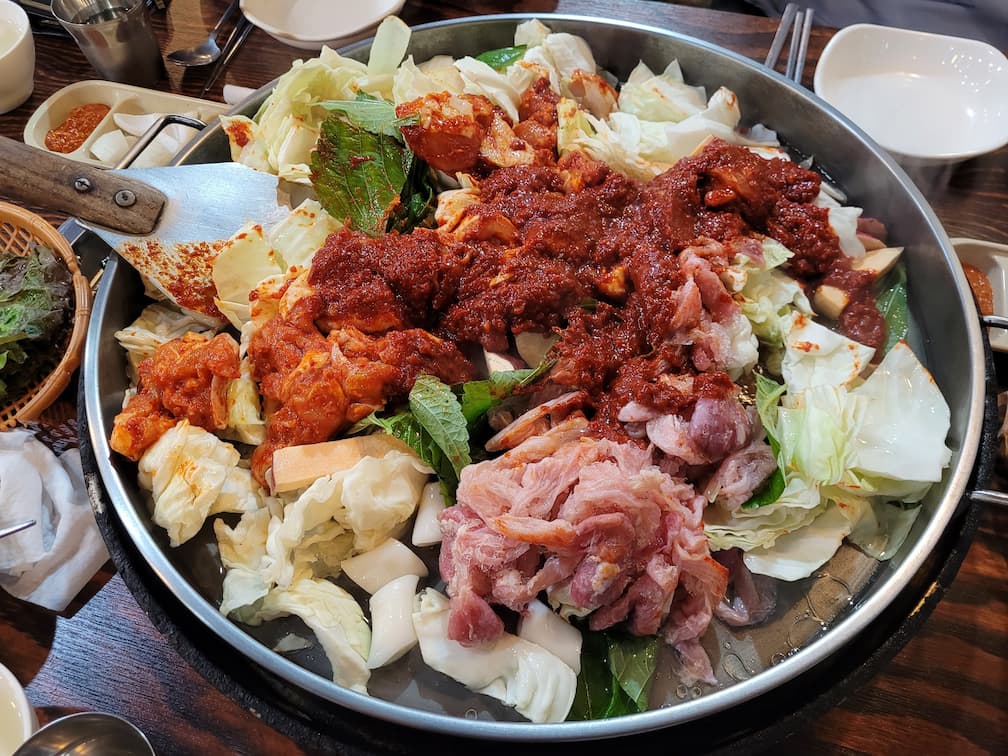 산속에 닭갈비 철판에 올려진 생닭과 양념