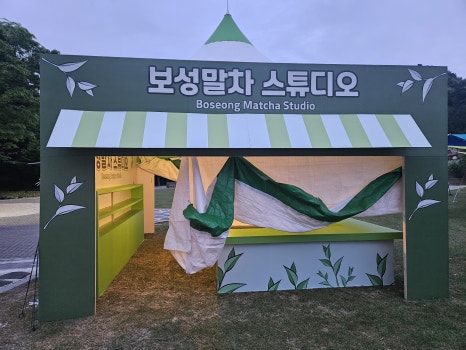 몽골텐트 전면에 커스텀 아치와 실사출력물을 적용한 행사부스 제작 모습