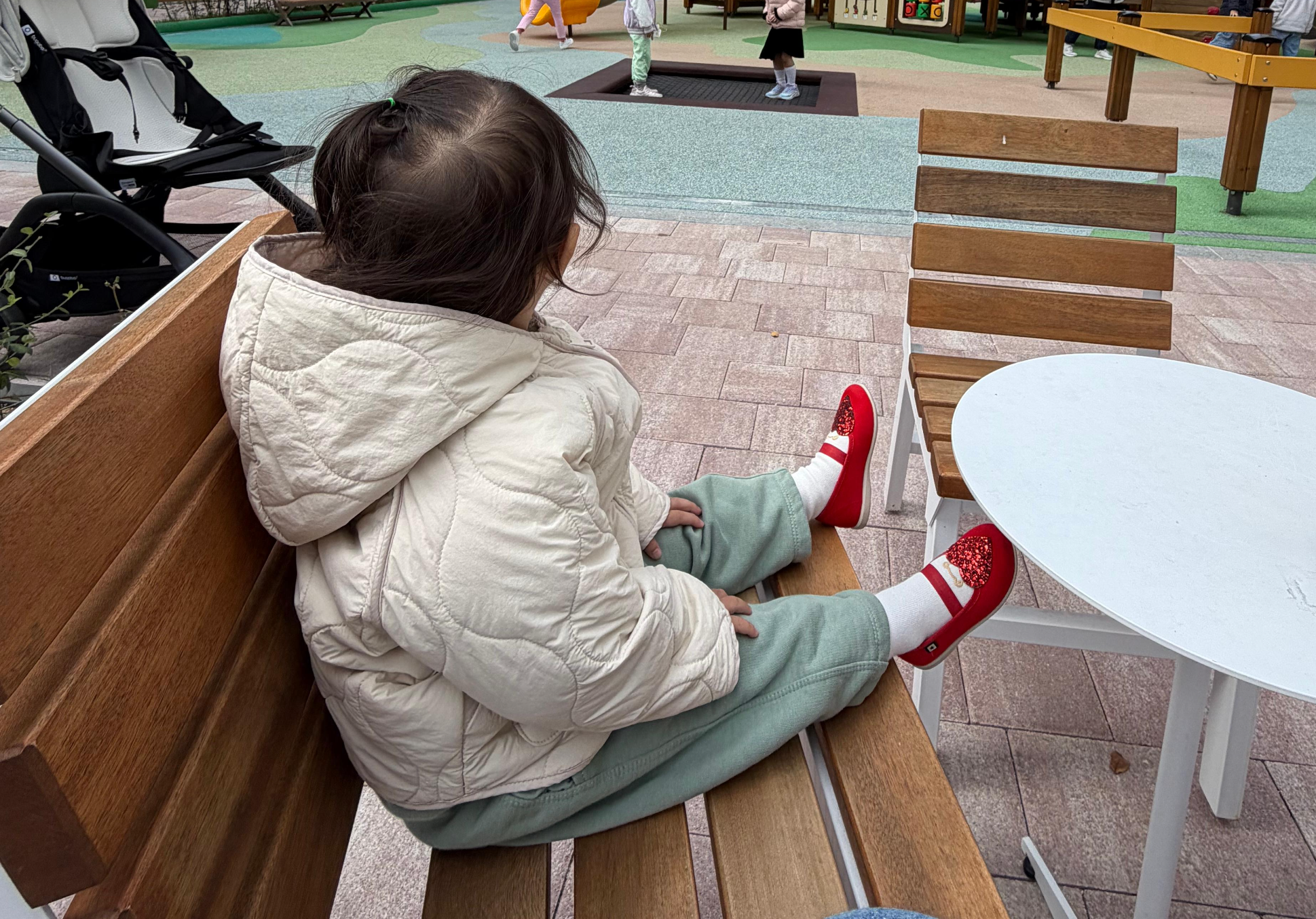 아파서 힘이 없어 놀이터에서 친구들을 바라보는 아기