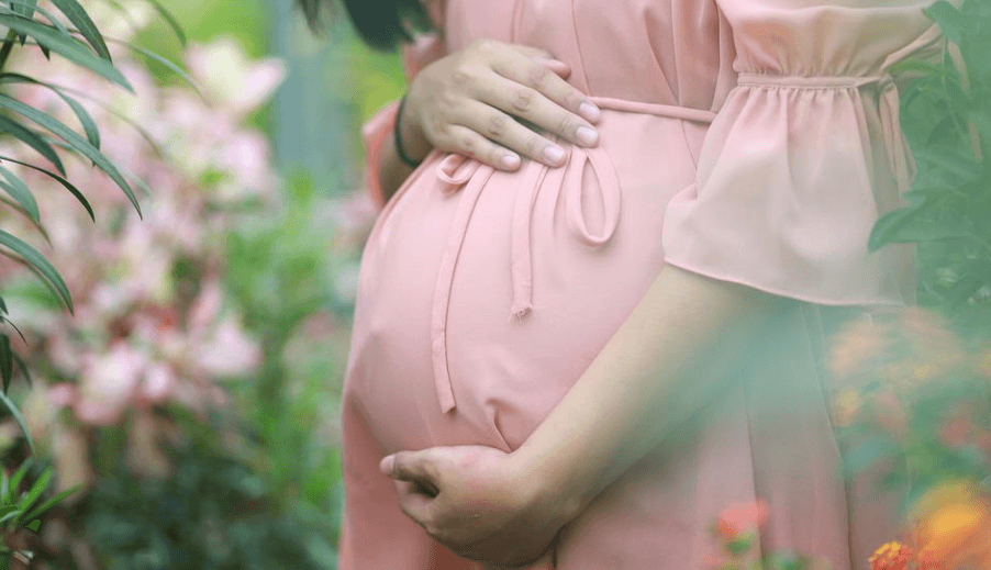 임산부가 꽃밭 속에 서 있다