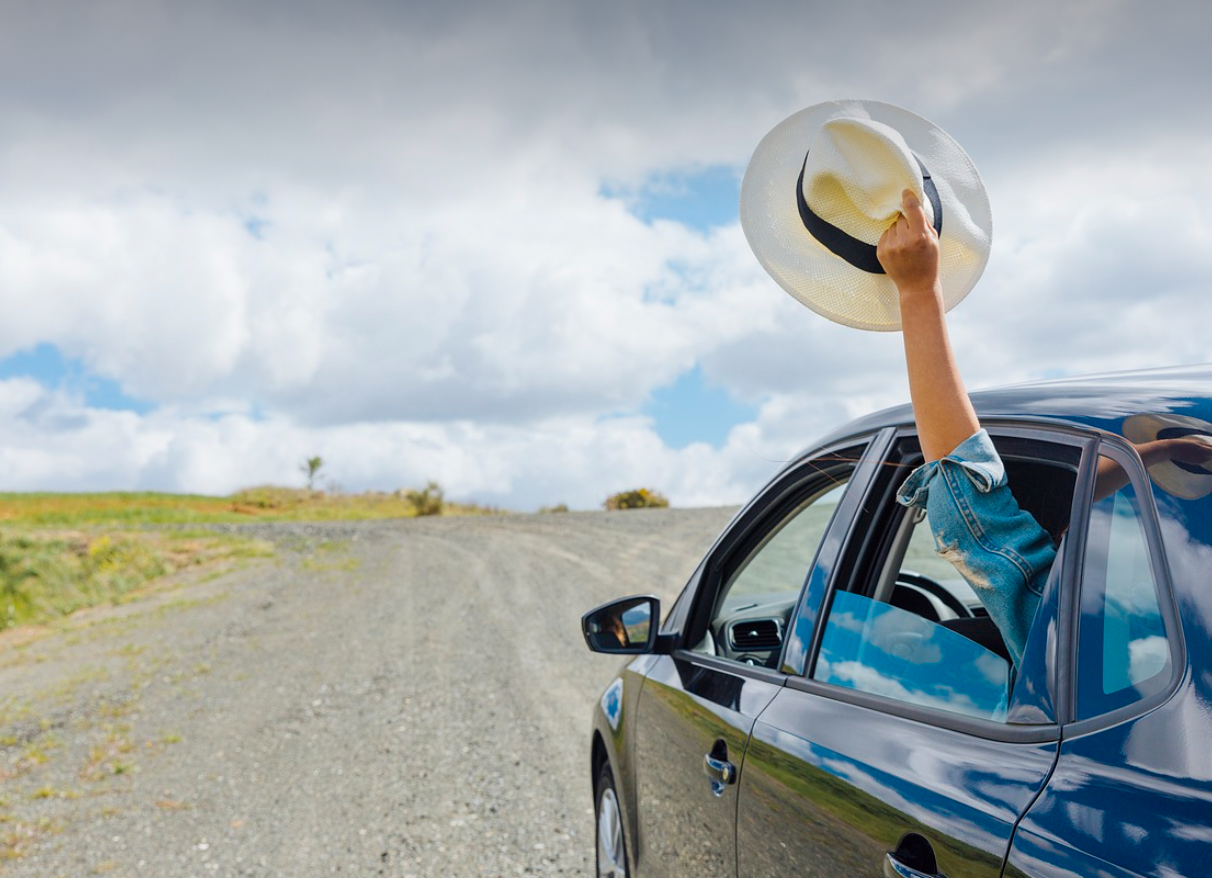 차를 타고 가다 여행자가 손을 밖으로 뻗어 모자를 흔드는 장면그림