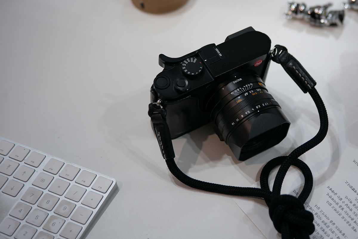 책상 위에 올려진 라이카 Q2를 사선으로 찍어, 매크로 링을 강조한 사진