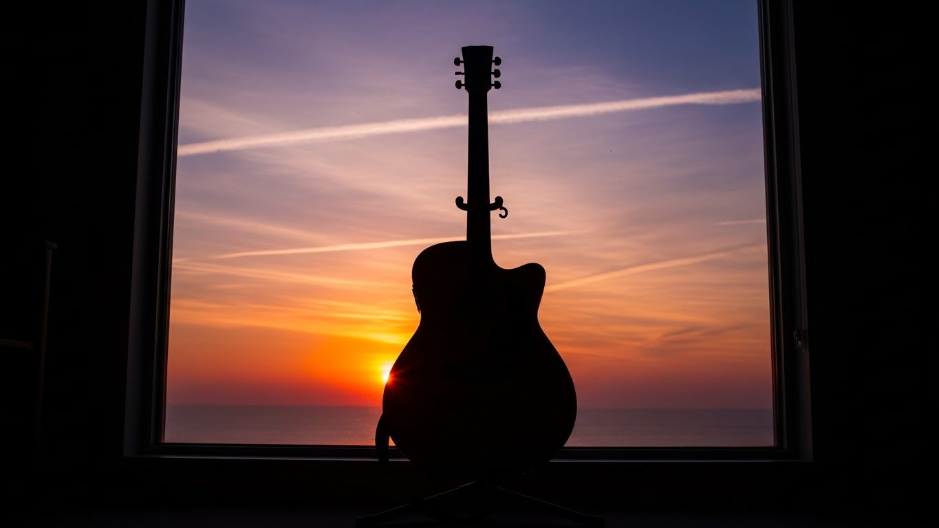 [이미지 #3: 연습을 마치고 기타 스탠드에 세워진 기타와 창밖의 노을]