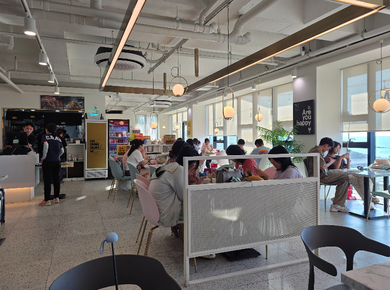 제주협재점 bhc 내부 모습. 사람들이 테이블에 앉아 있다