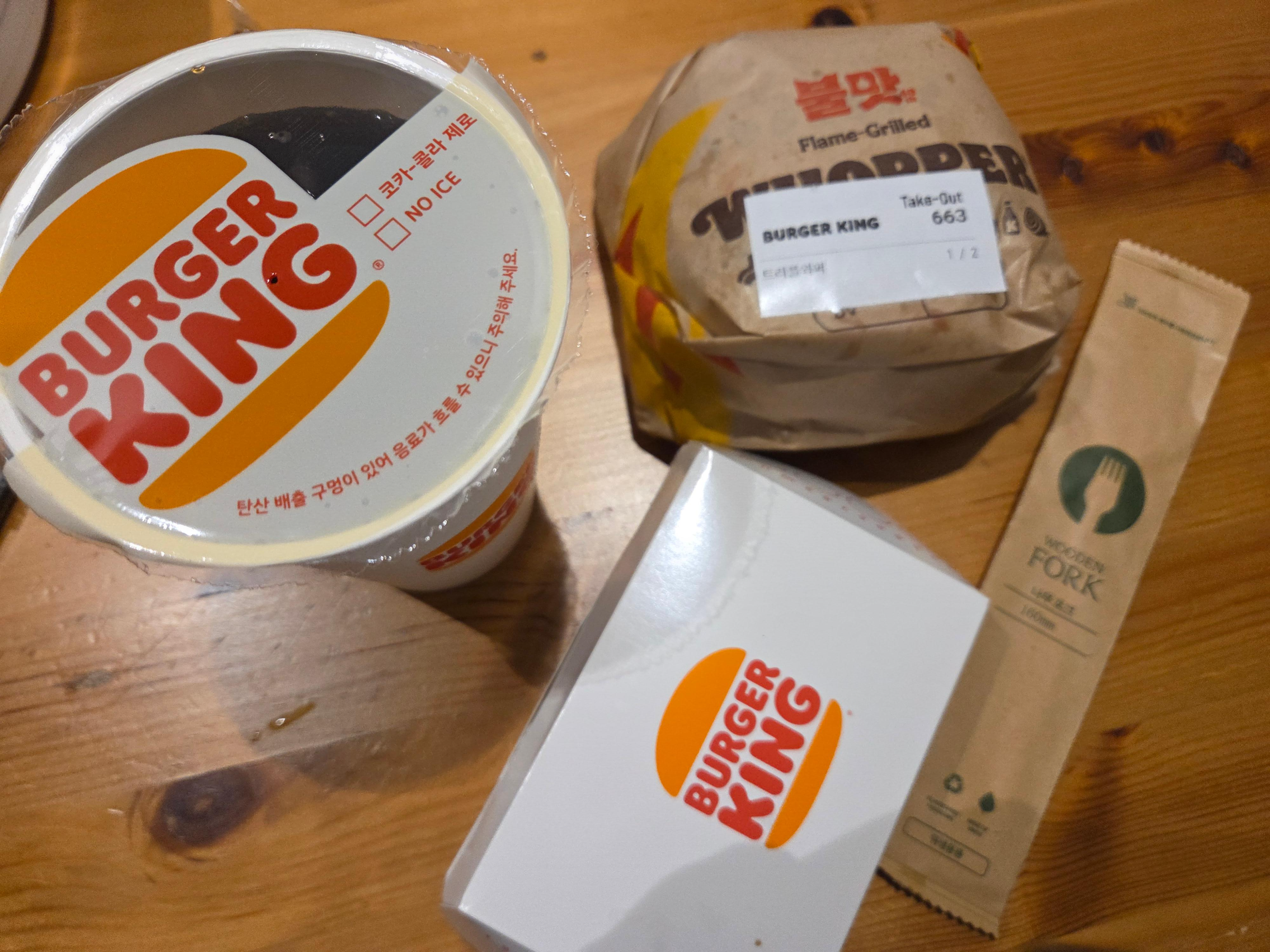 버거킹 트러플 머쉬룸 와퍼 세트를 포장해 테이블에 올려둔 사진으로 버거와 감자튀김, 음료 구성이 담긴 모습