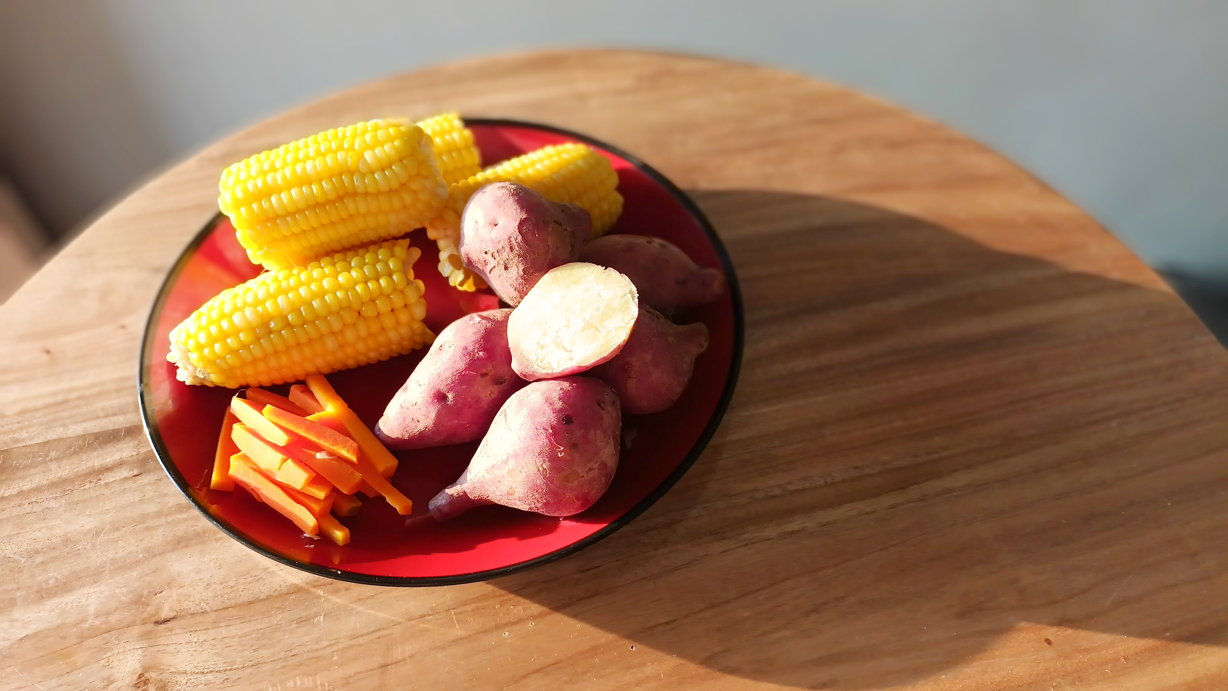 고구마, 옥수수, 당근 등 탄수화물 간식이 담긴 접시 &ndash; 다이어트 중 포만감만 믿고 선택하는 고탄수화물 간식 예시