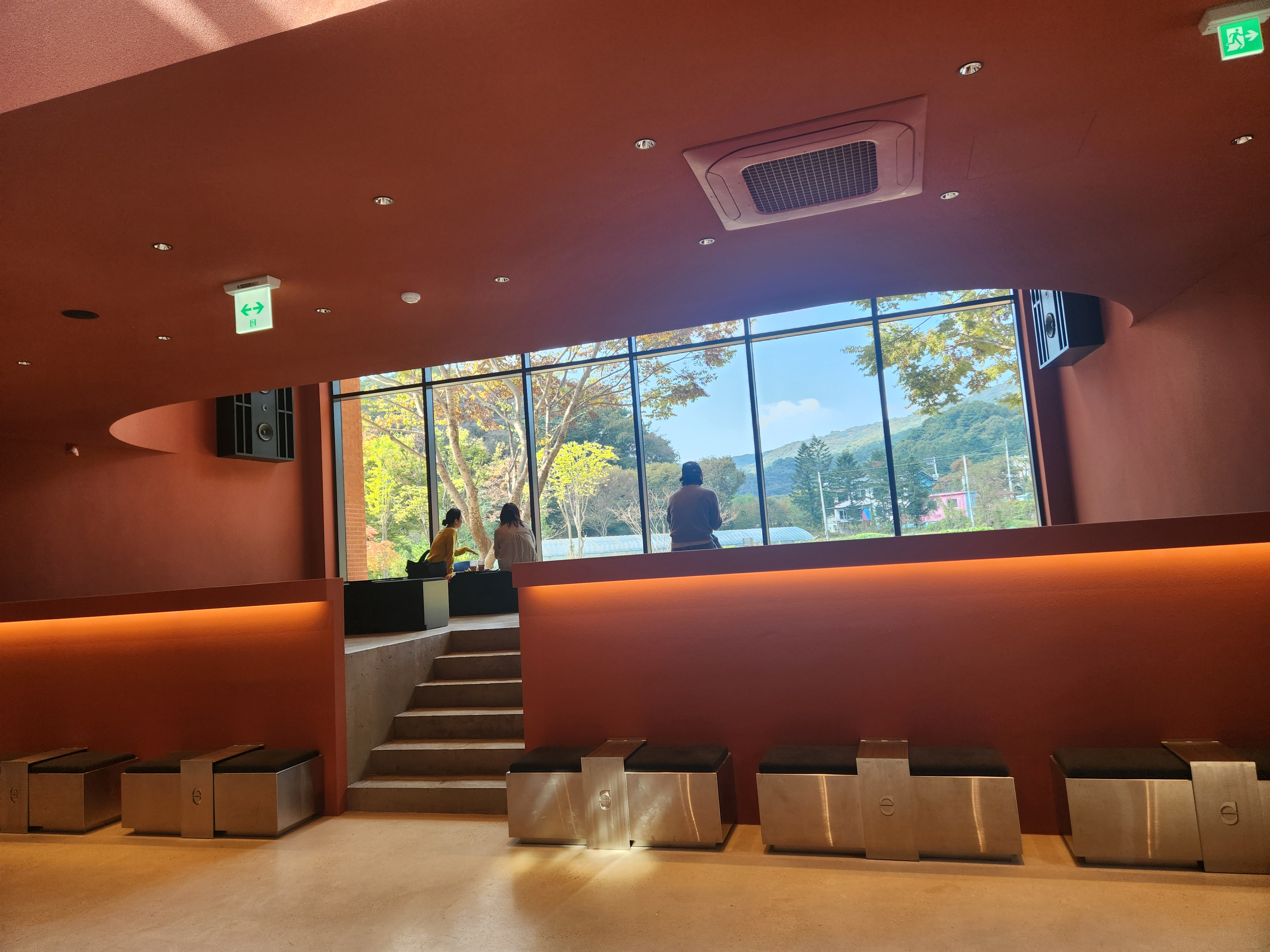 양 옆에 대형 스피커가 설치되어 있고-통창으로 남한산성이 보임-청음공간-낮은 테이블과 의자