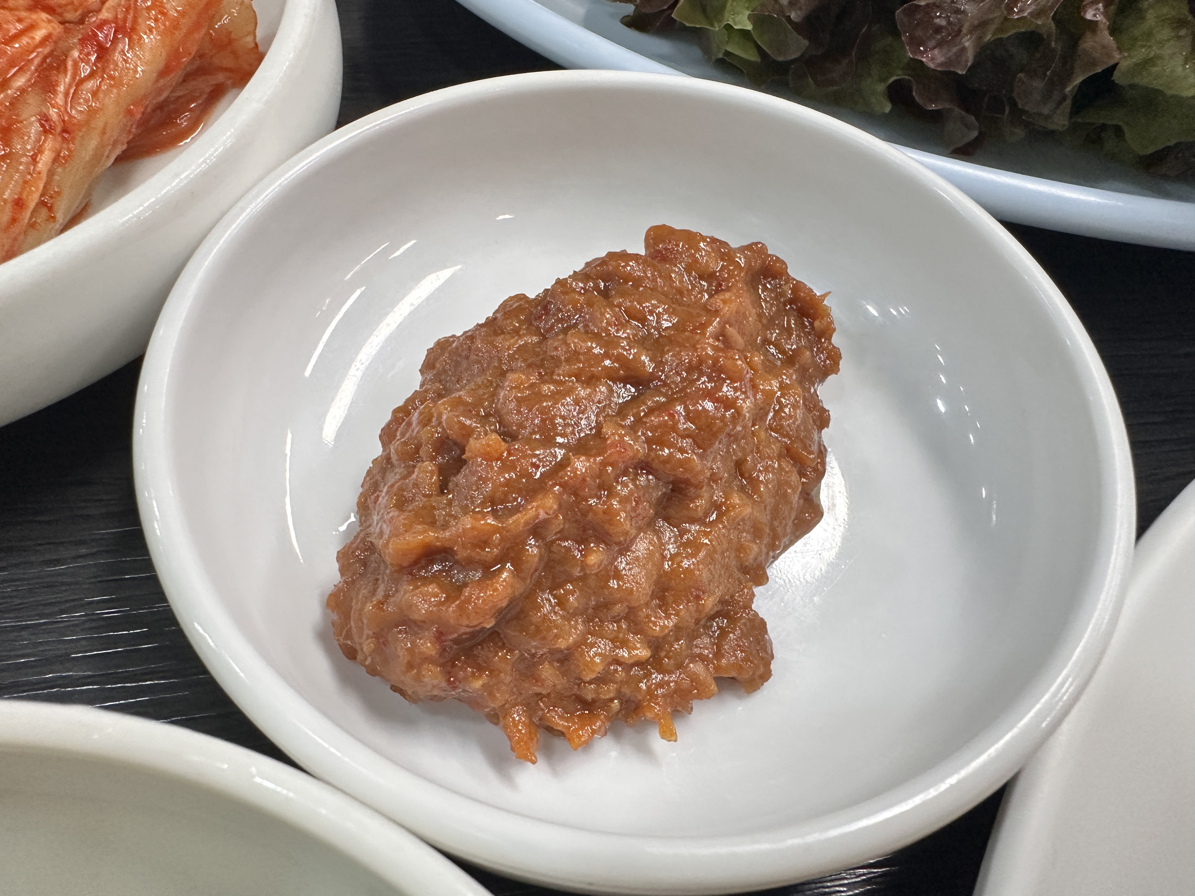 하얀 작은 접시에 담긴, 강된장처럼 진한 색의 특제 쌈장 클로즈업