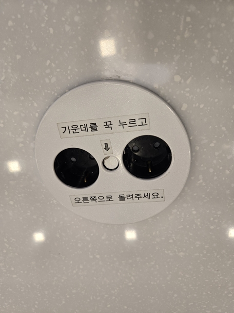 KFC 황금점 테이블 위 전원 콘센트 &ndash; &lsquo;사용 후 닫아주세요&rsquo; 안내 문구 포함