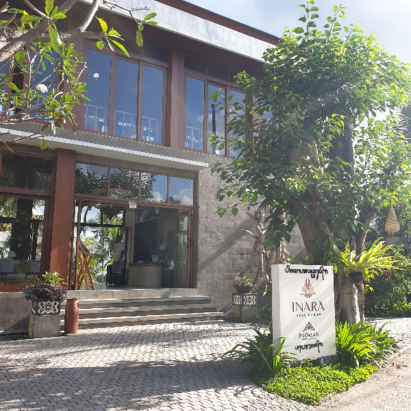 Inara Alas Harum 로비 건물 2층으로 되어있고 2층에는 창이 크다. 1층은 문이 열려 있다. 밖에 나무와 작은 입간판이 있다.