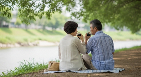 강가 나무 그늘에서 커피를 마시는 중년 커플