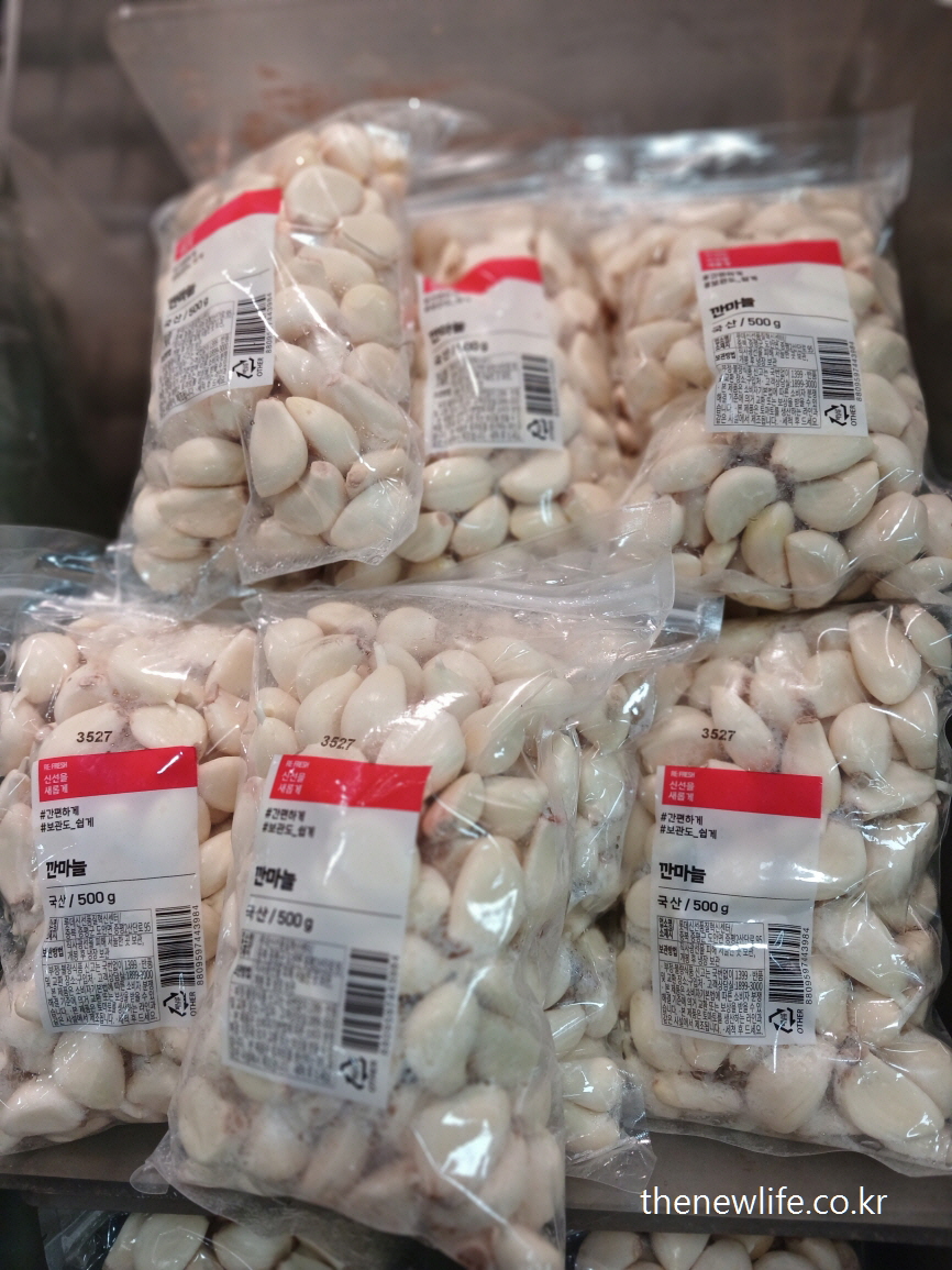 Bags of peeled garlic on display at a Korean market – 고지혈증에 좋은 음식인 깐마늘이 진열된 모습