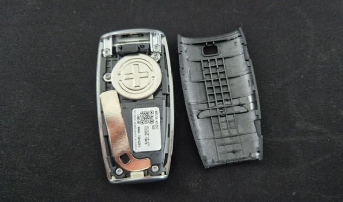 제네시스 스마트키 분해 중 건전지 교환 과정을 설명하는 사진