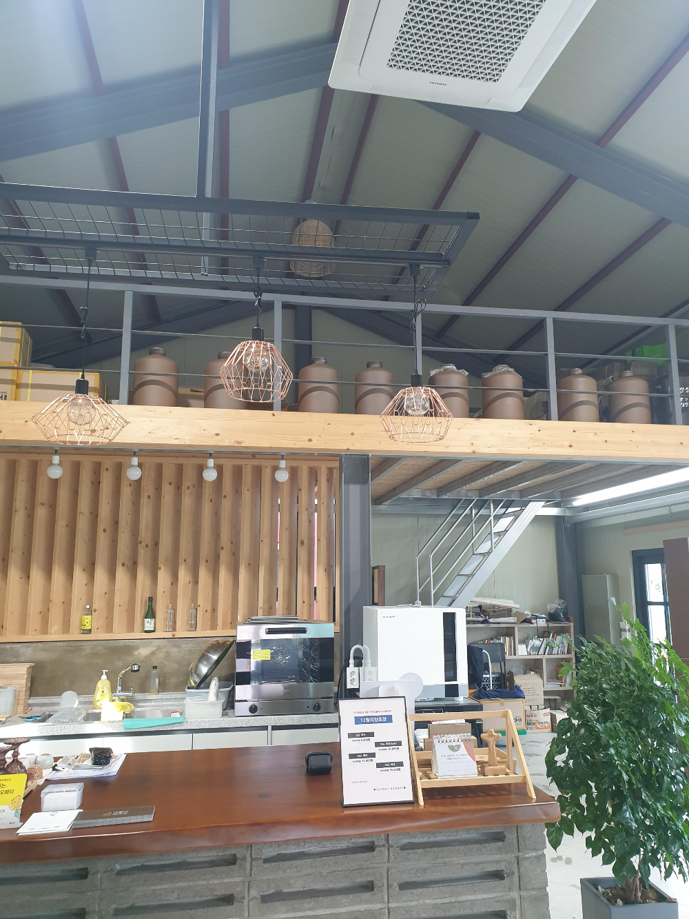 내부 2층에 술독들이 보이고 1층에는 테이블이 있다.