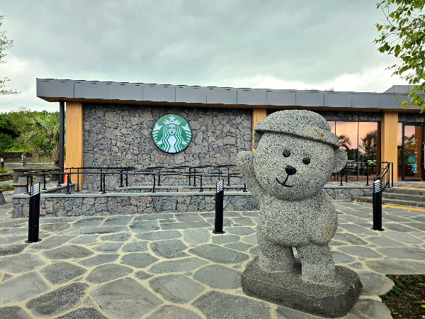 제주 금악 스타벅스 앞 모습, 제주 금악 스타벅스 전경. 하루방 닮은 모습과 스타벅스 로고가 보인다.