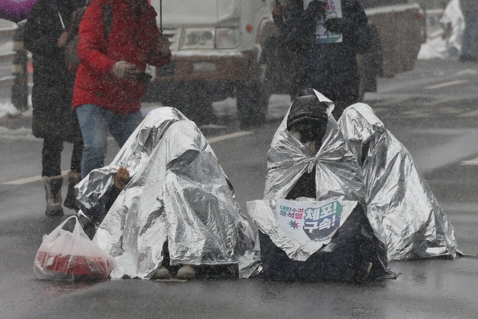 키세스 시위대 모습이다. 눈내리는 길위에 은박 담요를 감싸고 앉아서 윤석열 대통령 퇴진을 위한 시위를 진행하고 있다.