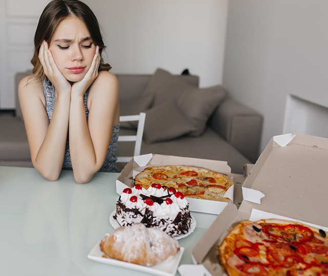 한 여성이 음식이 먹고싶은 것을 참느라 괴로워 하는듯한 표정을 짓는 사진