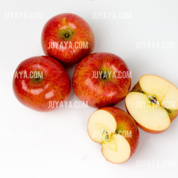 흰 배경 위에 잘 익은 빨간 사과 네 개와 반으로 잘린 사과. 심장 건강과 소화 개선에 효과적.