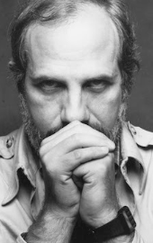 손을 모으며 앞을 바라보는 브라이언 드 팔마