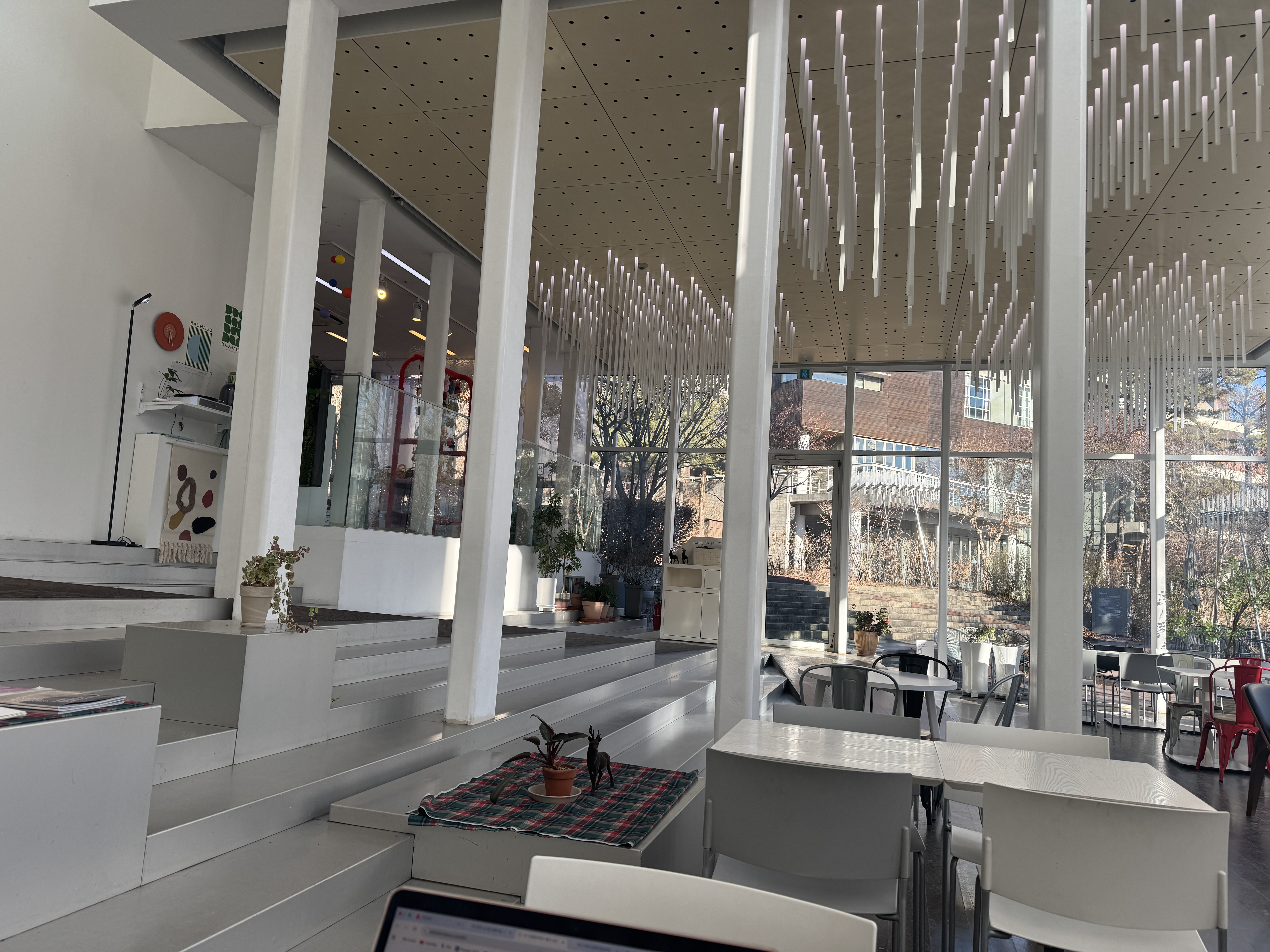 파주 헤이리 아트센터 화이트 블럭 카페 내부 전경, 높은 층고와 기둥 구조가 돋보이는 공간