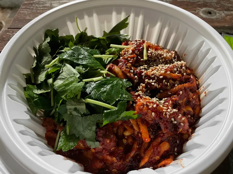 포장된 그릇에 가오리회무침과 깻잎이 올려진 모습