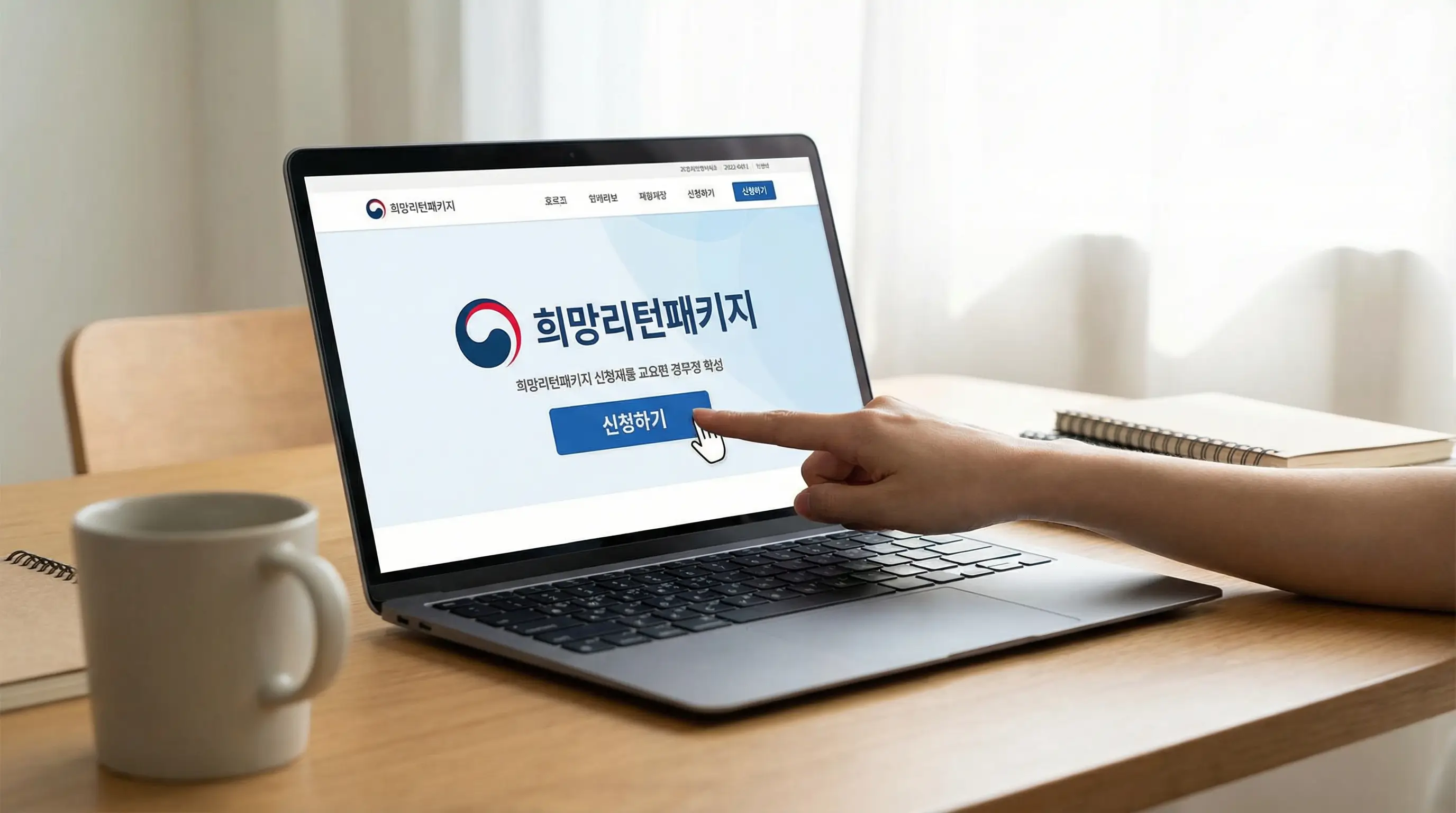 노트북 화면에 희망리턴패키지 공식 홈페이지가 띄워져 있고 신청 버튼을 클릭하는 손