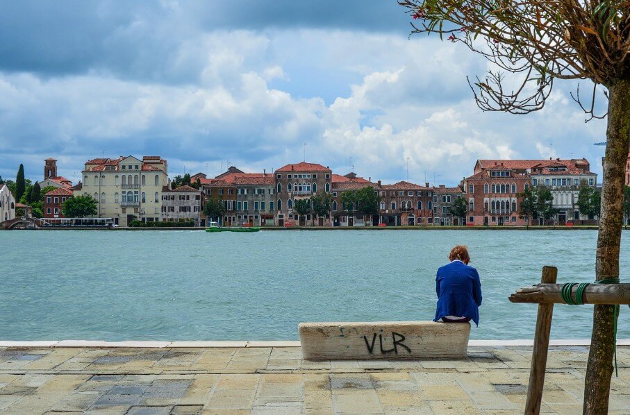 강물이 보이는 벤치에 앉아 있는 노인