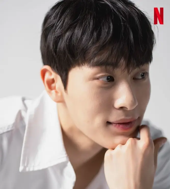 솔로지옥 3 - 흰색 셔츠를 입고 오른쪽을 바라보며 왼손으로 턱을 괴고 있는 최민우