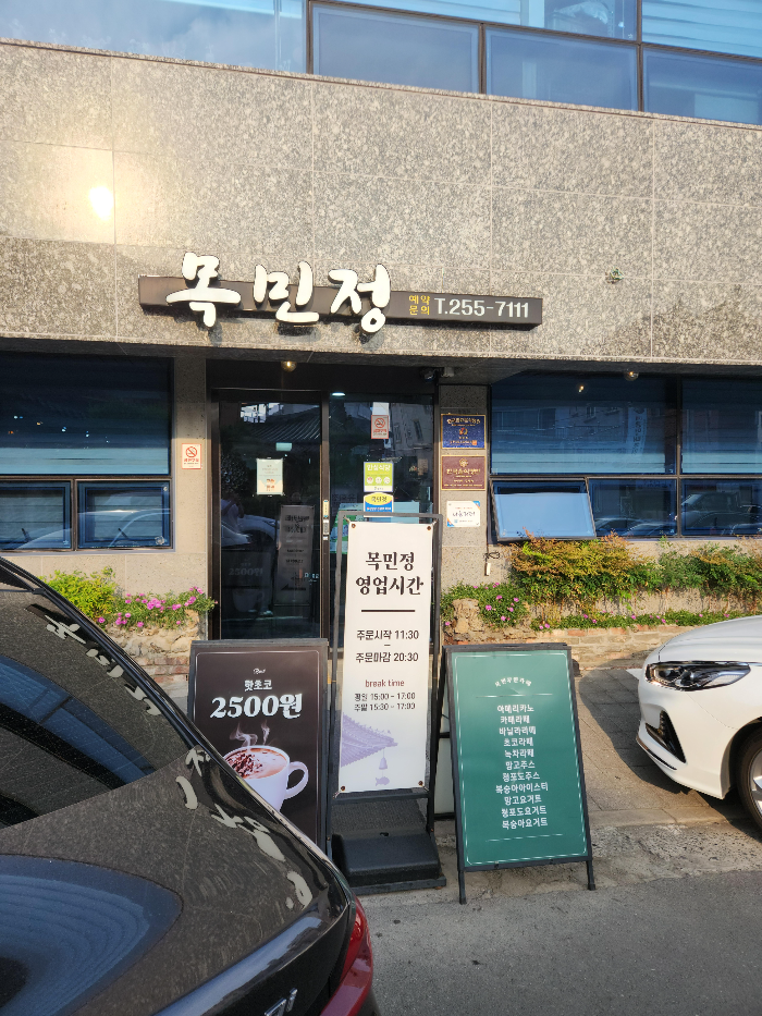 목민정 입구 정면에서 찍은 사진이다 영업시간 등을 안내하고 있는 입간판이 함께 있다