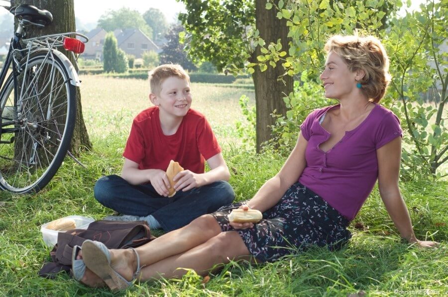 자전거를 타고 잠시 앉아 샌드위치를 나눠 먹으며 함께 웃는 사만다와 시릴