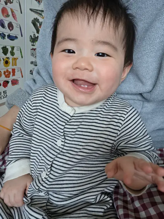 엄마품에 앉아서 웃고 있는 아기