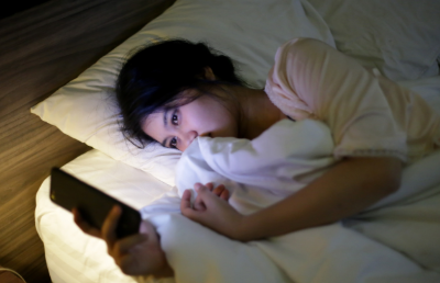 잠자기전 핸드폰을 보는 여성