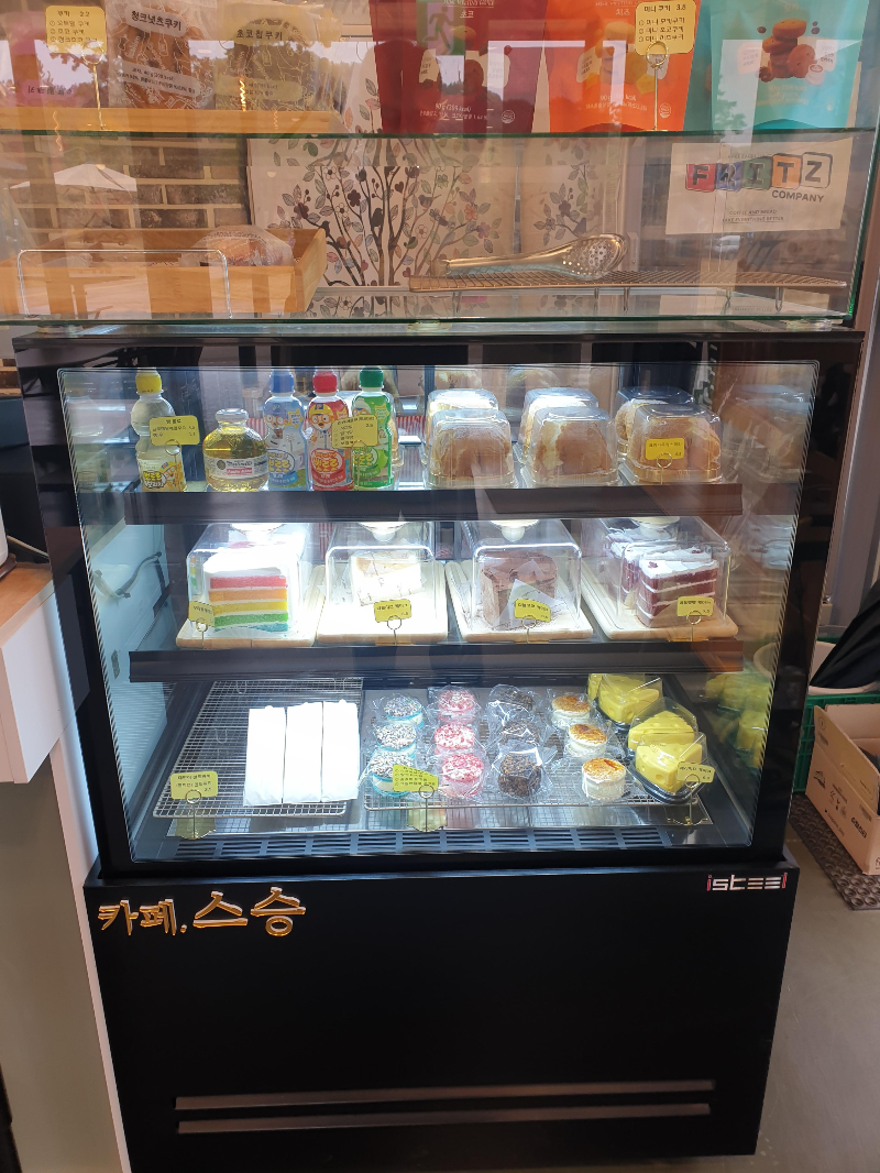 냉장고 진열대에 놓인 디저트류(케익, 카스테라, 마카롱)