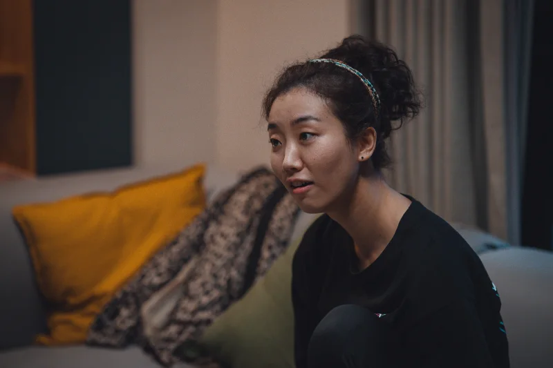 어느 거실을 배경으로 소파에 앉아 누군가와 대화를 하고 있는 영화 타켓의 오달자