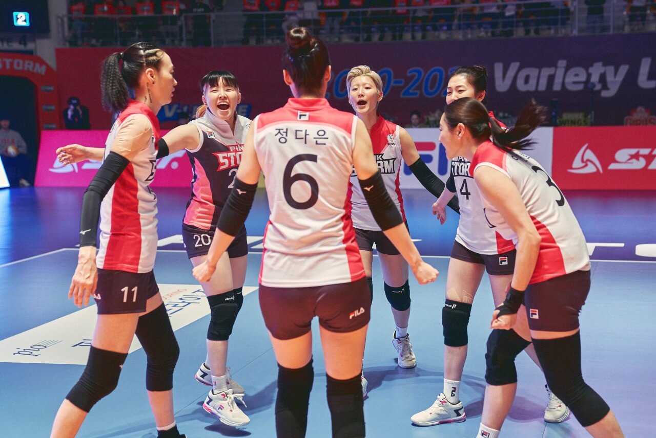 배구 선수들이 코트에서 환하게 웃고 있는 모습