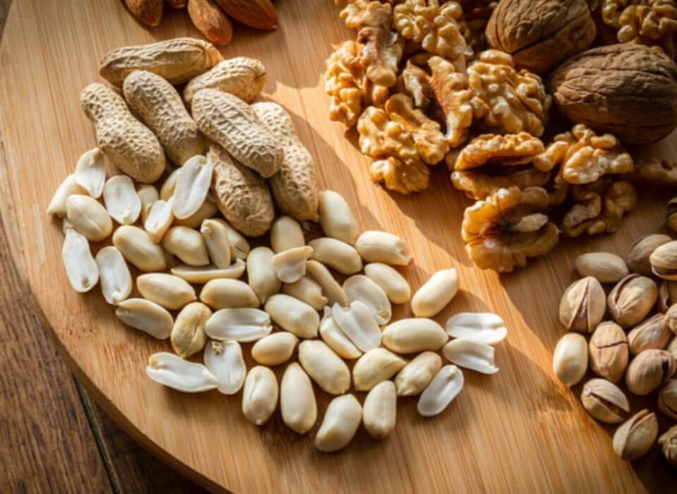 땅콩, 호두, 피스타치오 등 견과류가 나무그릇 위에 놓여있는 사진
